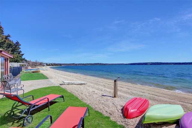 property view of water with fence and a beach view