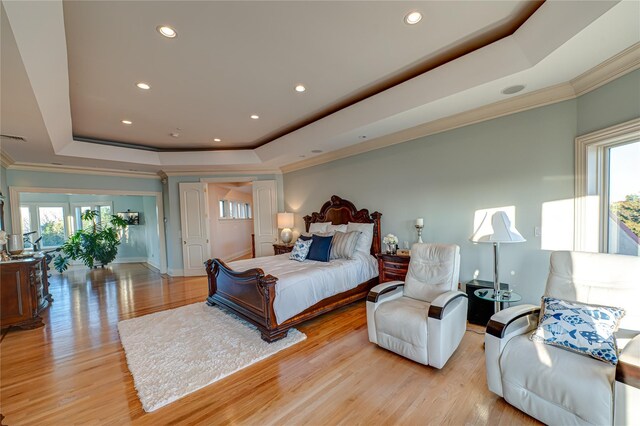bedroom featuring recessed lighting, a raised ceiling, and multiple windows