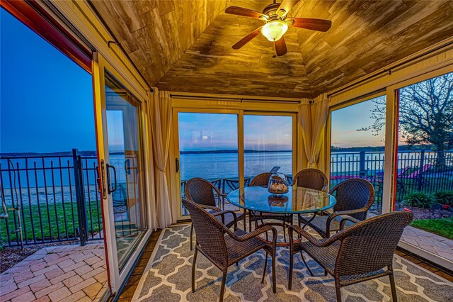 sunroom / solarium featuring a water view, vaulted ceiling, and wood ceiling