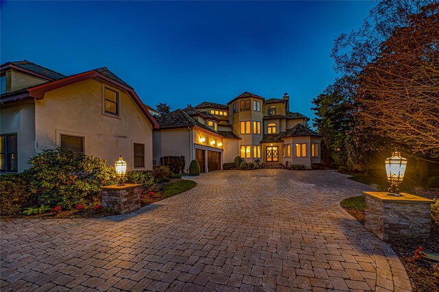 mediterranean / spanish-style house featuring decorative driveway and stucco siding