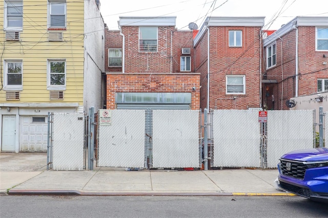 view of front facade with brick siding, a gate, and a fenced front yard