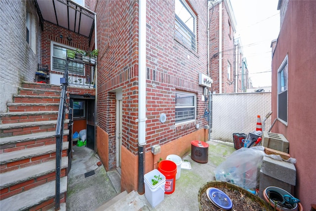 view of home's exterior with brick siding and fence