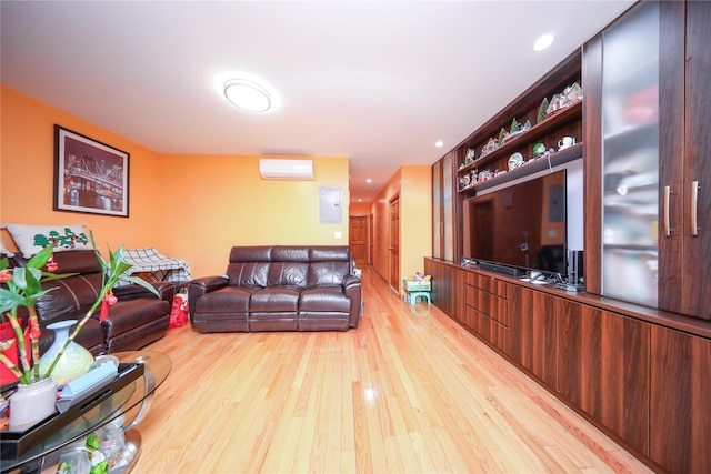 living room with a wall unit AC, light wood-style floors, and recessed lighting
