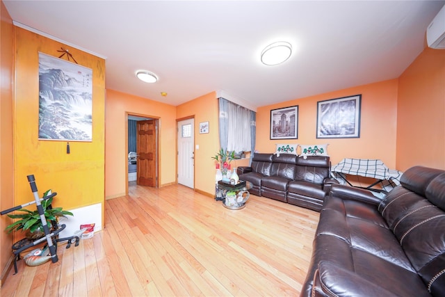 living area with hardwood / wood-style flooring, baseboards, and a wall mounted AC