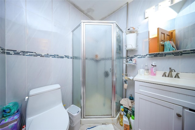 full bath with a stall shower, tile walls, toilet, and vanity