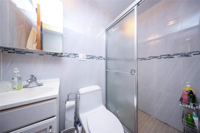 full bathroom featuring tile walls, a stall shower, vanity, and toilet