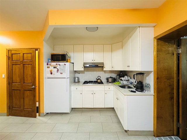 kitchen with stainless steel appliances, under cabinet range hood, light countertops, and white cabinetry
