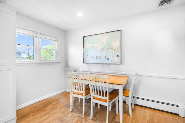 dining area with recessed lighting, a baseboard heating unit, baseboards, visible vents, and wood finished floors