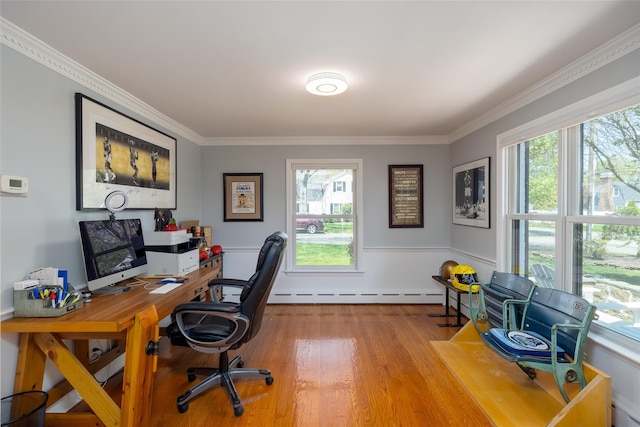 office space with ornamental molding, baseboard heating, and plenty of natural light