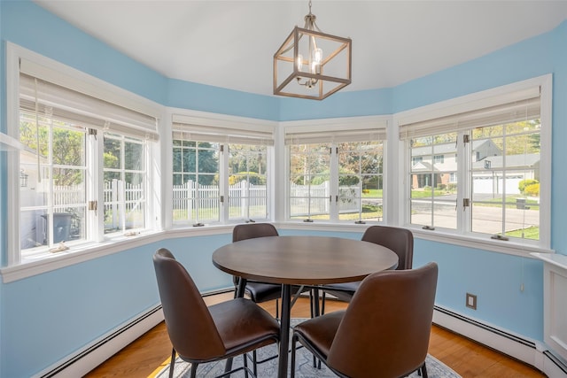 sunroom featuring an inviting chandelier, wood finished floors, french doors, and a baseboard heating unit