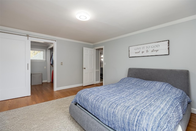 bedroom featuring wood finished floors, ornamental molding, and baseboards