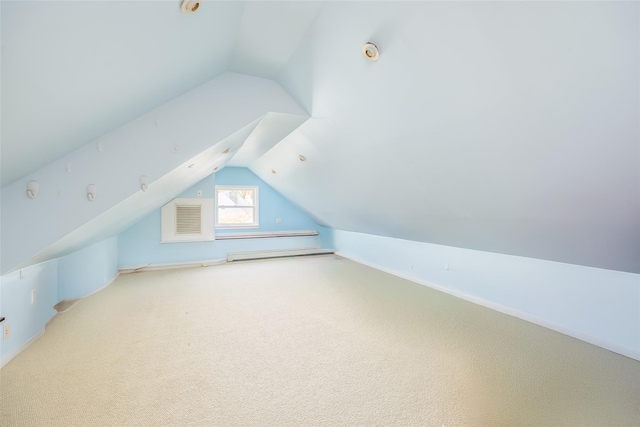 additional living space with baseboards, carpet flooring, and vaulted ceiling