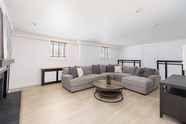 living room with plenty of natural light, light wood finished floors, and crown molding