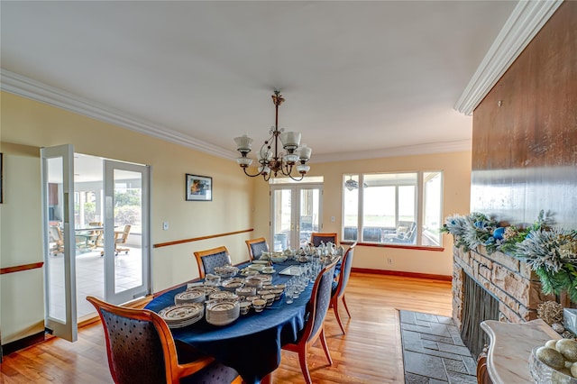 dining space with ornamental molding, light wood-style flooring, and a notable chandelier