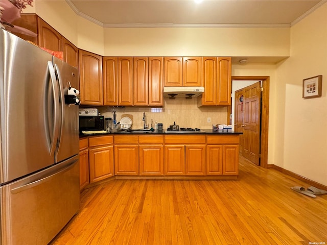 18-24 College Point Blvd, College Point, NY 11356 - kitchen featuring freestanding refrigerator, ornamental molding, under cabinet range hood, dark countertops, and light wood-style flooring