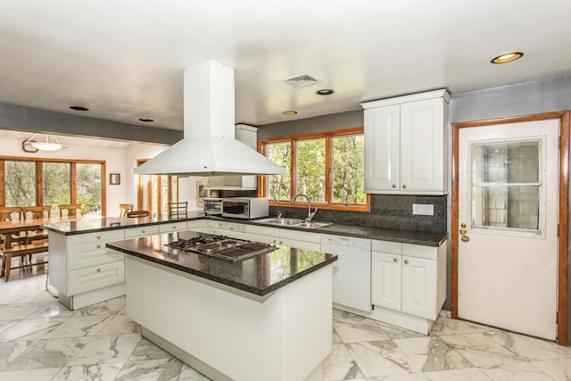 kitchen featuring a sink, a peninsula, stainless steel appliances, and white cabinetry