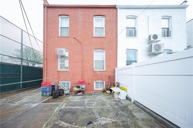 2250 E 23rd St, Brooklyn, NY 11229 - rear view of property featuring fence, a patio area, stucco siding, and ac unit
