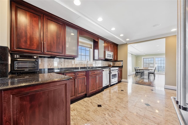 83 Central Ave, Amityville, NY 11701 - kitchen with baseboards, tasteful backsplash, a healthy amount of sunlight, and appliances with stainless steel finishes