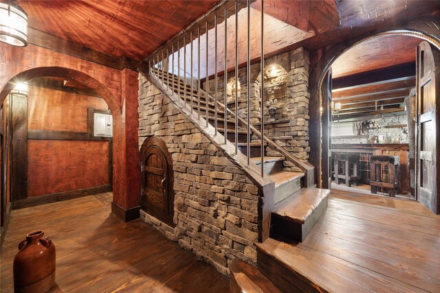 83 Central Ave, Amityville, NY 11701 - wine area featuring beamed ceiling, wooden ceiling, wood-type flooring, wooden walls, and arched walkways