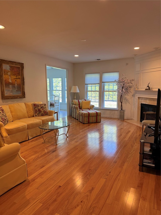 living room featuring recessed lighting, light wood finished floors, and a premium fireplace