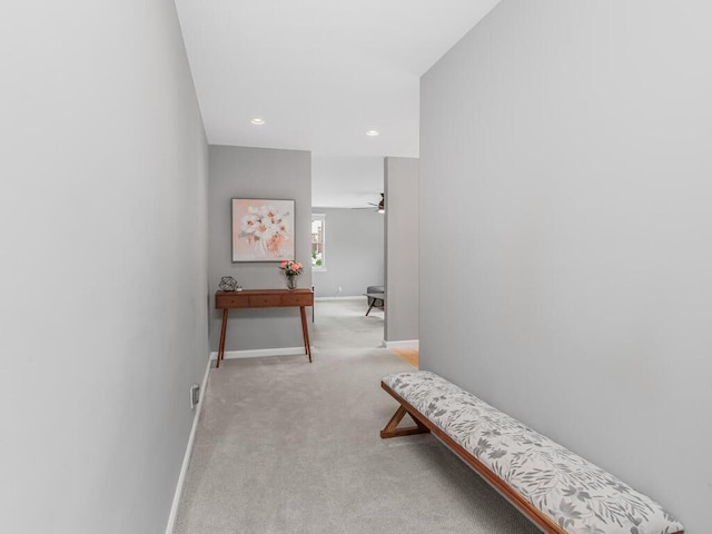 hallway with baseboards, recessed lighting, and light colored carpet