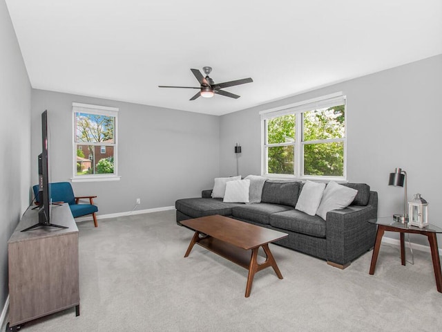 living room with light colored carpet, baseboards, and ceiling fan