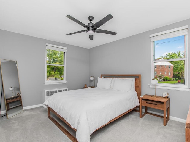 carpeted bedroom featuring radiator, baseboards, and a ceiling fan