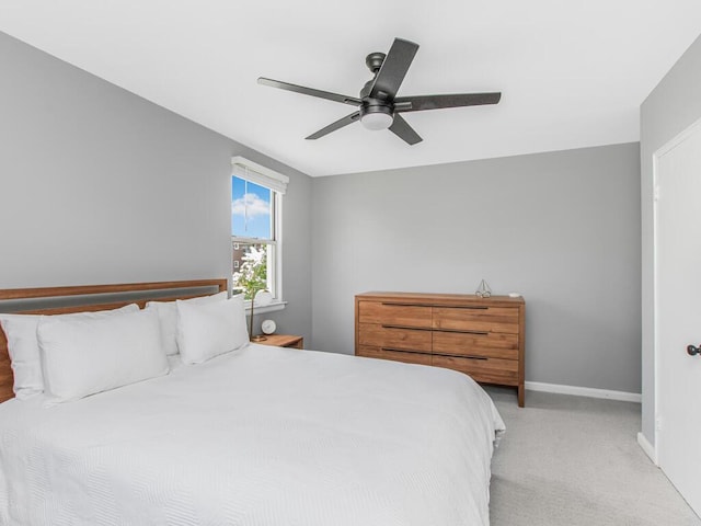 bedroom featuring light carpet, baseboards, and ceiling fan