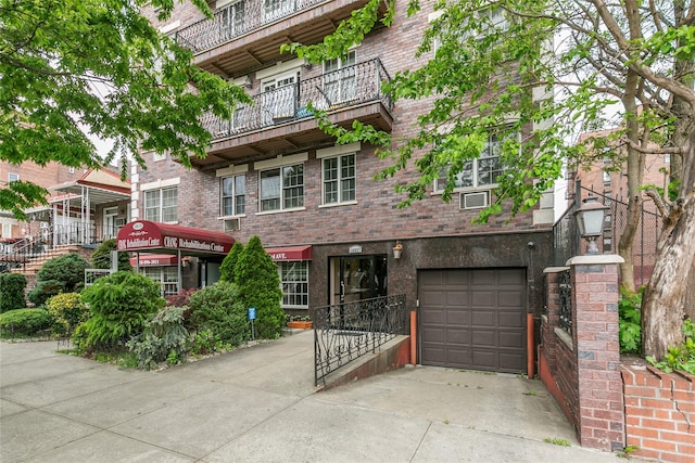 108-27 63rd Ave Unit 4B, Forest Hills, NY 11375 - view of front facade featuring concrete driveway, an attached garage, and brick siding
