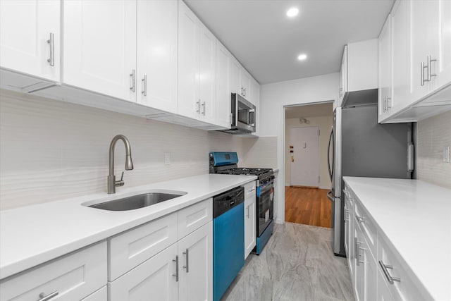 kitchen featuring a sink, light countertops, tasteful backsplash, and stainless steel appliances