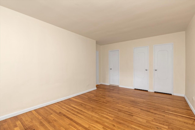 unfurnished room with baseboards and light wood finished floors