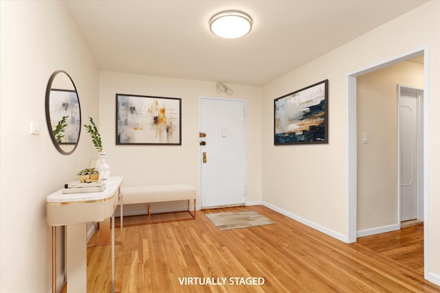foyer featuring baseboards and light wood-style floors