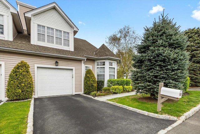 view of front of house featuring a garage, roof with shingles, and driveway