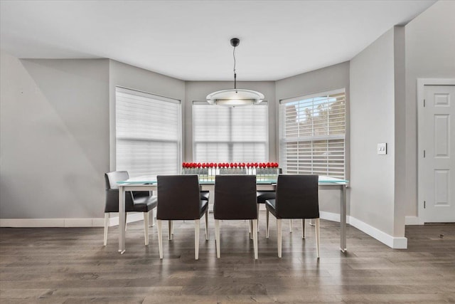 dining area with baseboards and wood finished floors