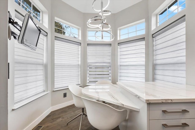 interior space featuring baseboards, a chandelier, a wealth of natural light, and dark wood-style floors