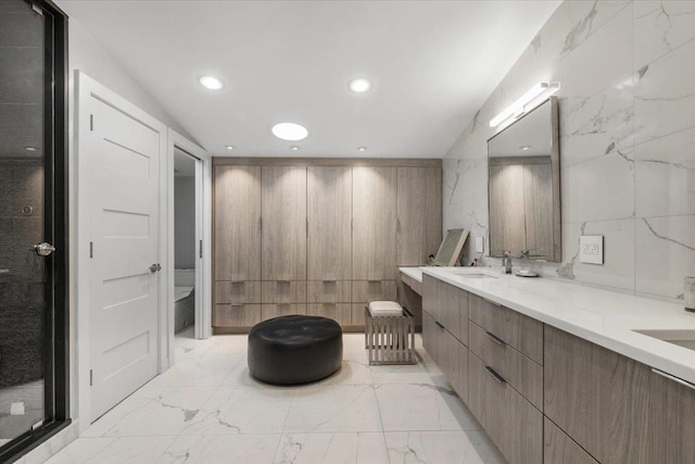 bathroom featuring double vanity, marble finish floor, toilet, recessed lighting, and a sink