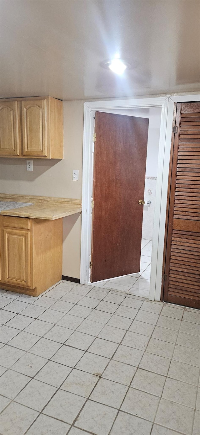 kitchen featuring light countertops, light tile patterned floors, and light brown cabinets