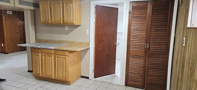 kitchen featuring light countertops, ventilation hood, light tile patterned floors, and light brown cabinets