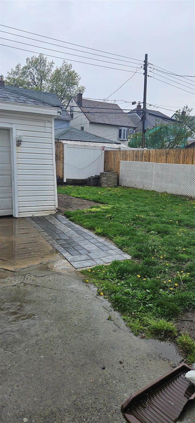 view of yard featuring fence and an outbuilding