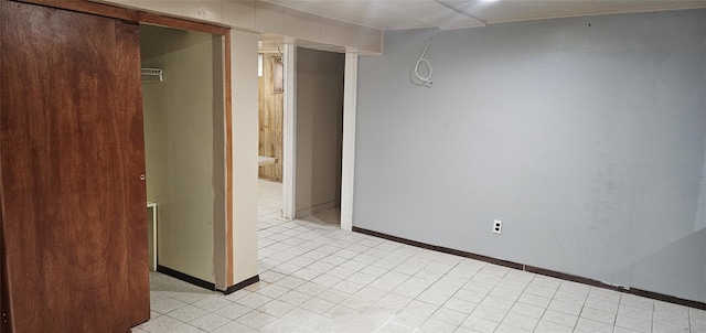 empty room with light tile patterned floors and baseboards