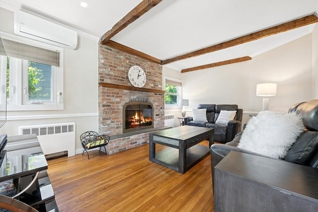 37 Remson St, Valley Stream, NY 11580 - living area with radiator heating unit, a wall unit AC, wood finished floors, beamed ceiling, and a brick fireplace
