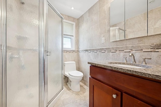 37 Remson St, Valley Stream, NY 11580 - bathroom with tile walls, vanity, toilet, a stall shower, and tile patterned floors
