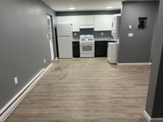 kitchen featuring baseboards, white cabinets, light wood-style floors, under cabinet range hood, and white appliances