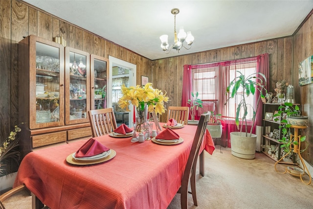 carpeted dining room with wooden walls and a notable chandelier