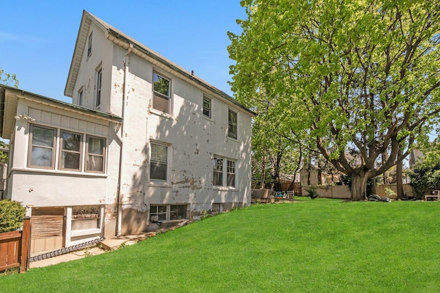 92 Ridgewood Ave, Yonkers, NY 10704 - back of house with a lawn, fence, and stucco siding