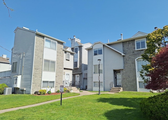 view of building exterior featuring central air condition unit and entry steps