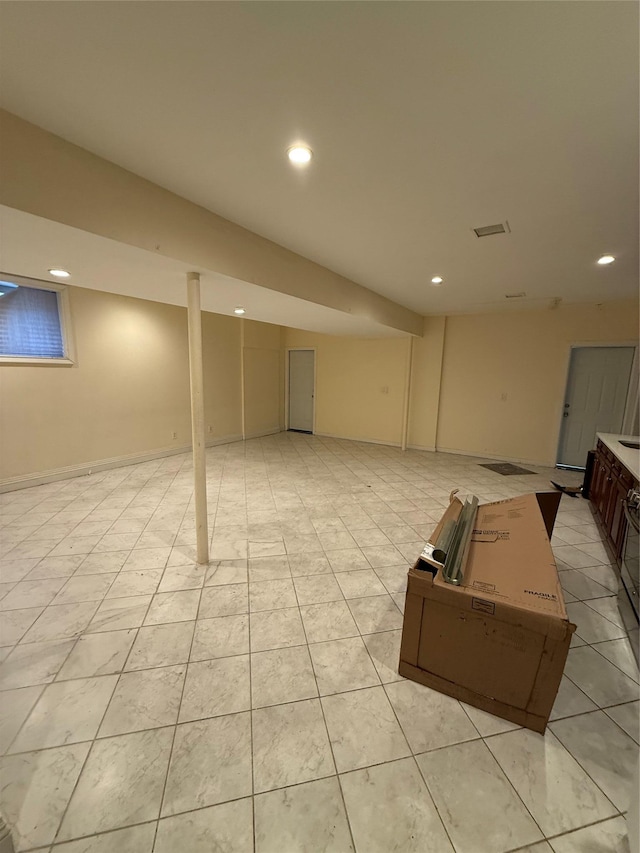 finished below grade area featuring recessed lighting and light tile patterned floors