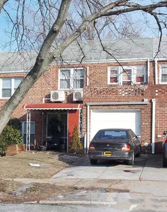 25-19 120th St, College Point, NY 11356 - view of property featuring brick siding, driveway, and an attached garage