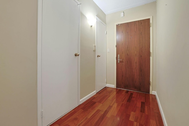 hall featuring baseboards and wood finished floors
