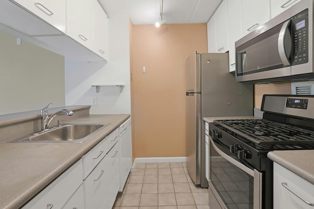 kitchen featuring white cabinetry, appliances with stainless steel finishes, light tile patterned floors, and a sink